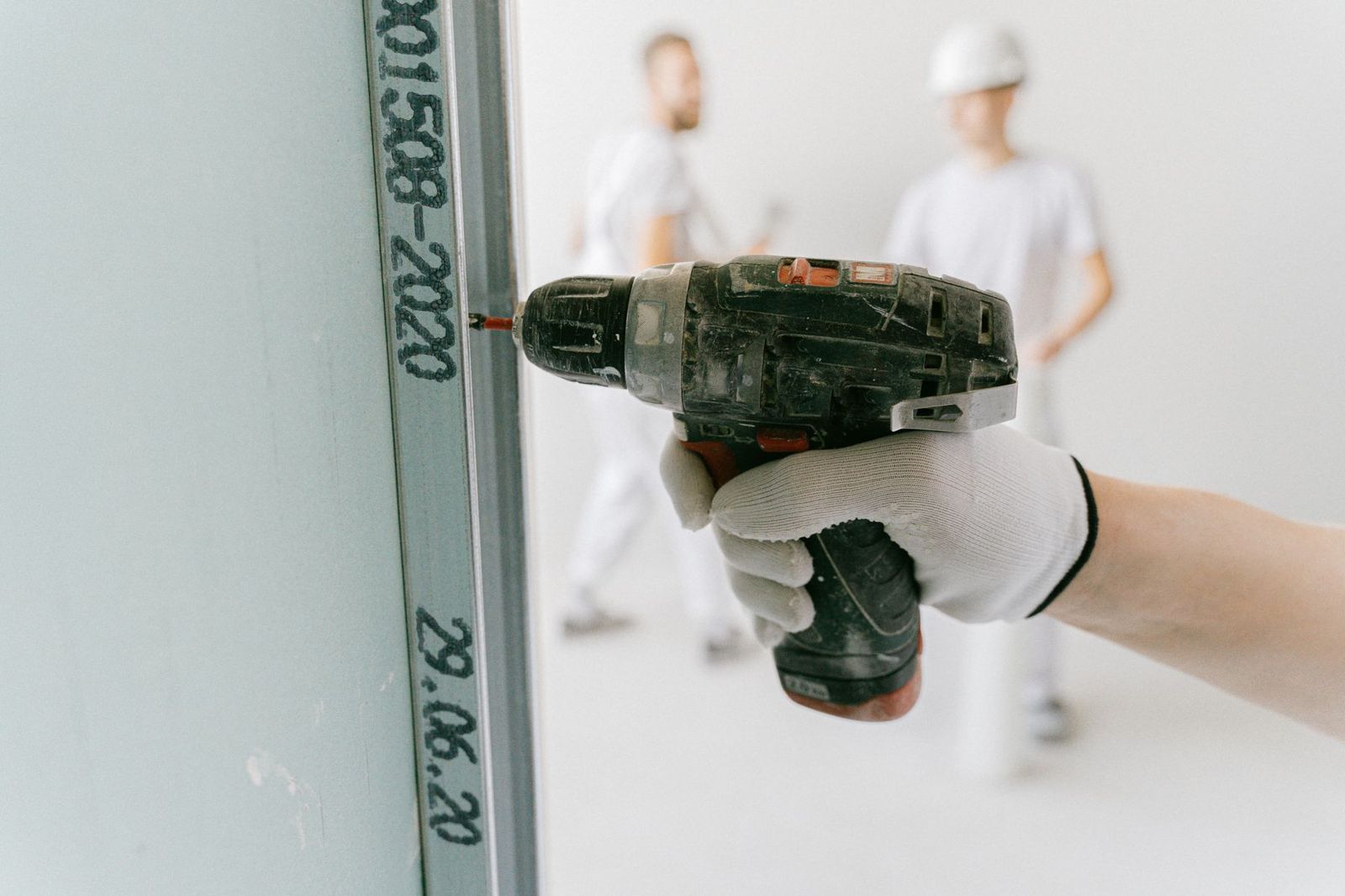 Handwerker bohrt in eine Gipskartonwand